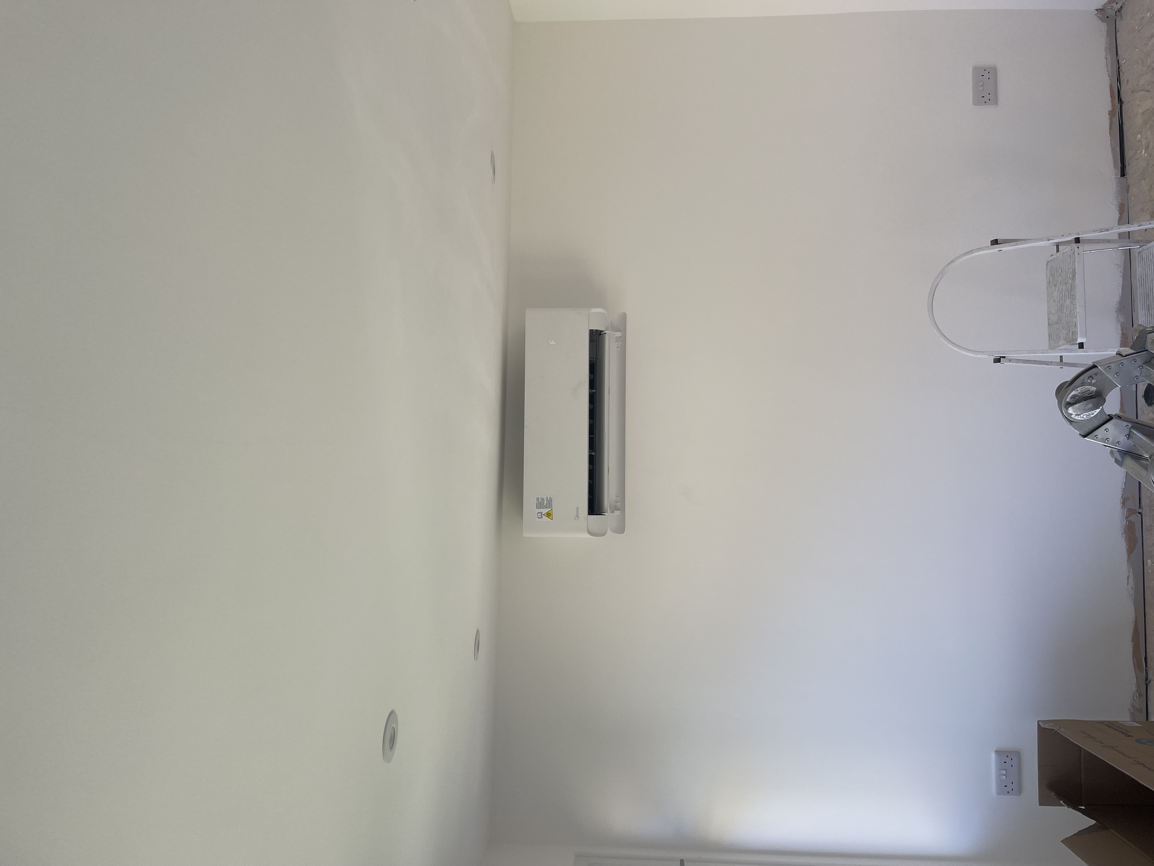 Engineer mid-installation of an interior wall split air conditioning unit